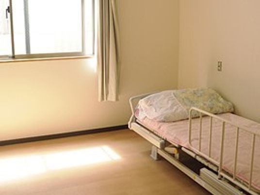 シンプルな居室には布団がセットされたベッドが置かれている。窓は大きく日当たりがよい。