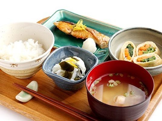 品数の多い食事メニューが写っている写真。鮭や酢の物、みそ汁などが写っている