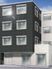 鉄骨造の建物が写っているパース。シックな色合いの建物がある。奥のほうに青空が見える