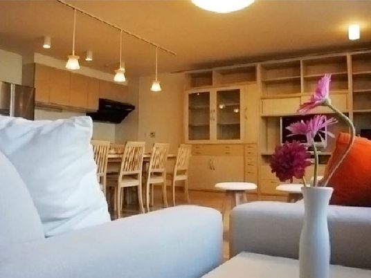 家庭的な雰囲気のダイニングとリラックススペース。手前にソファ、奥に食事を摂る場所