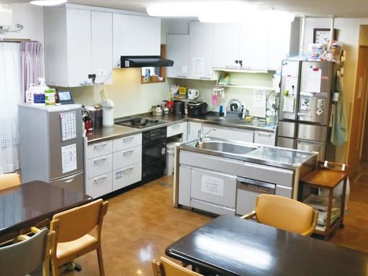 大きなキッチンが付いたリビングダイニングにはダイニングテーブルセットが複数置かれている。