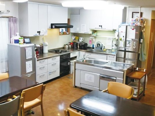 大きなキッチンが付いたリビングダイニングにはダイニングテーブルセットが複数置かれている。