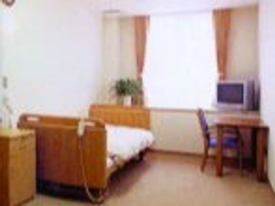 寝具付きのベッドやテレビ、デスクセットなどが置かれている居室にはカーテンが付いた大きな窓がある。