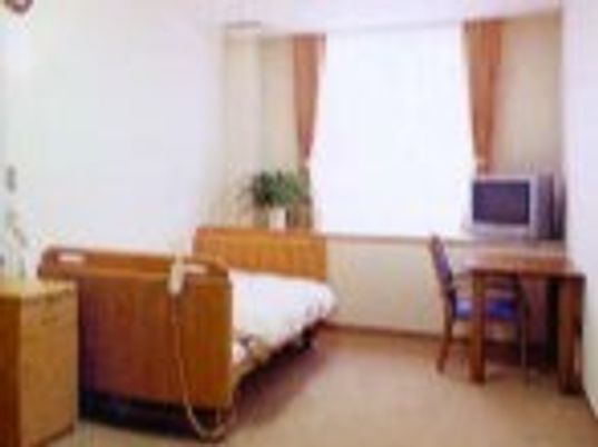 寝具付きのベッドやテレビ、デスクセットなどが置かれている居室にはカーテンが付いた大きな窓がある。