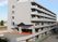 グレーの6階建ての建物はどっしりとしていて、1階部分が駐車場となっている。周りには背の高い建物はない。