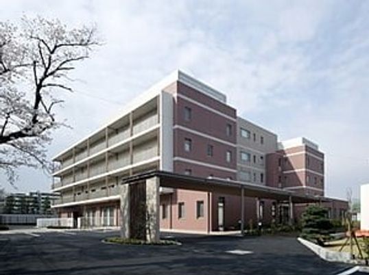 5階建ての建物は白とブラウンで各フロアにベランダが付き、広い敷地内には庭もある。