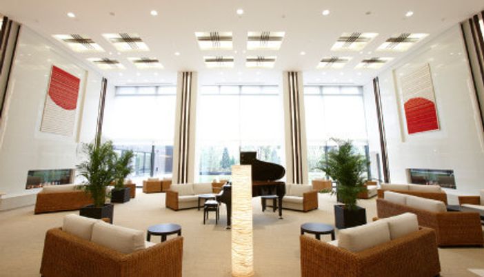 横に広く天井が高いリラックススペースの写真。ホテルのラウンジのようなスペース