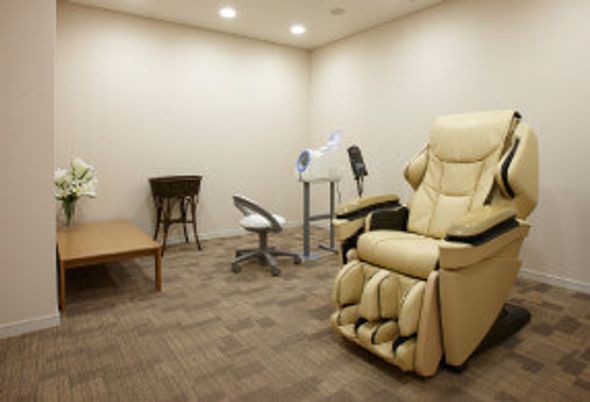 マッサージチェアのような大きな一人用ソファがあるワンルームの様子