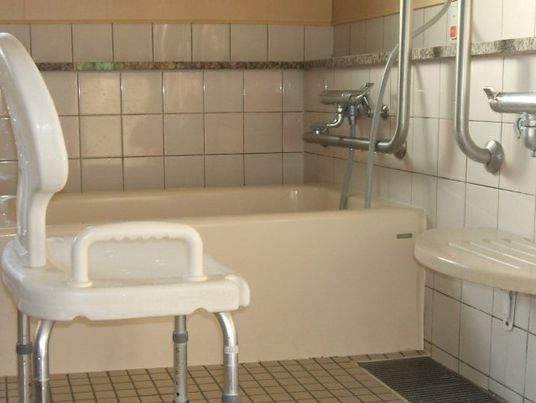 白いタイルが貼られた浴室には一人用の浴槽やシャワーチェがある。