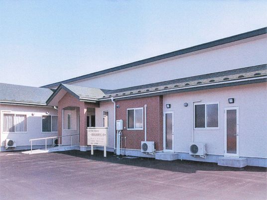平屋建ての建物には緑の屋根が付き、玄関にはスロープが付いている。