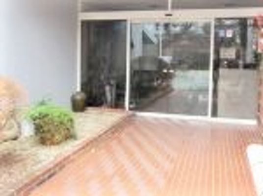 自動ドアと花壇が写っている施設のエントランス部分。バリアフリー構造のエントランス