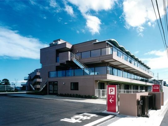鉄骨造の大きな建物お外観写真。ケアハウスらんの家の外観と敷地を写したもの