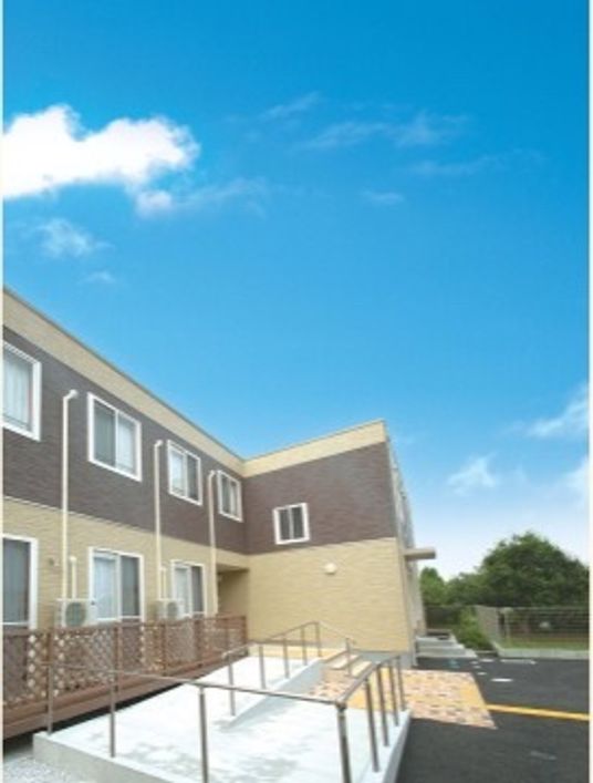 広い駐車場が配されたブラウンを基調とした街に馴染む同社２階建て施設