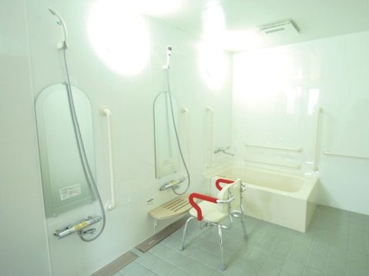 移動が楽な椅子を配し手すりのついた広く開放的な浴室