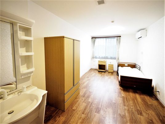 洗面所や緊急通報装置が設置されたフローリングの居室にはベッドやエアコンも付いている。