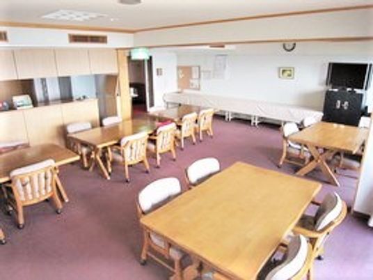 フローリング仕様の部屋に四人掛けのテーブルと椅子が並んでいるリビング