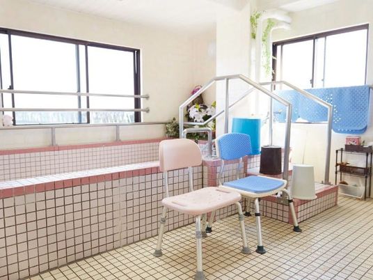 浴室に高齢者用のいす、手すりがそろっている様子が写っている。施設内の大浴場