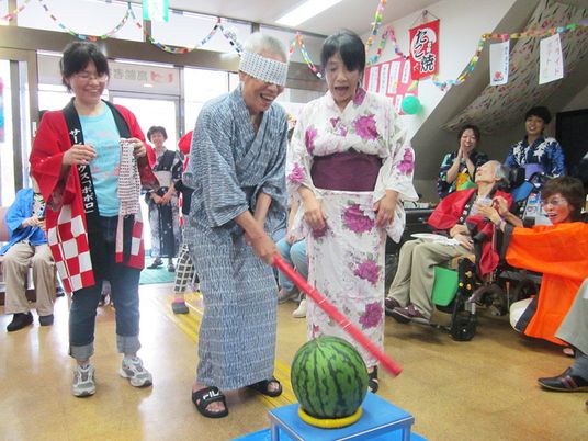 夏祭りで水変わりをしている様子。高齢者と地域の人との交流の様子
