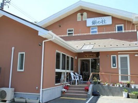 やわらかい色合いの建物の外観写真。スロープがついている施設のエントランス部分