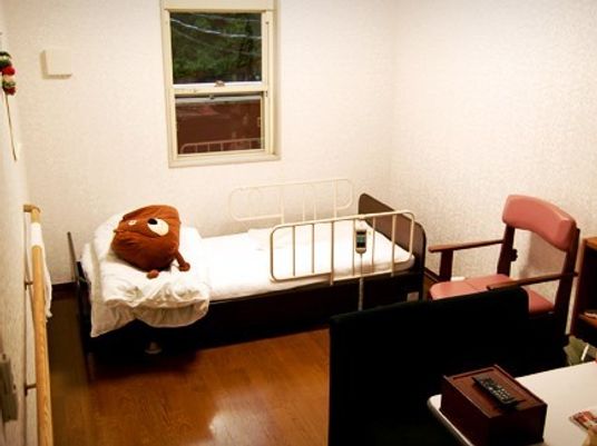 ベッドとたんす、いすなどが置いてある施設内の居室の様子