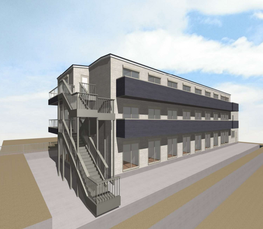 ベージュと紺の外壁で、向かって左側に階段がある3階建てグループホーム