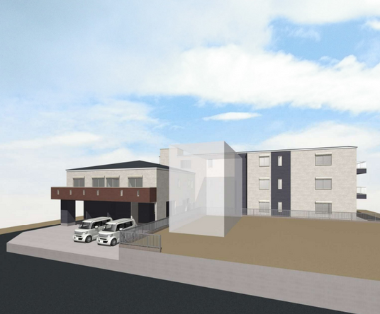 ベージュと紺の外壁で三角屋根の3階建てグループホーム