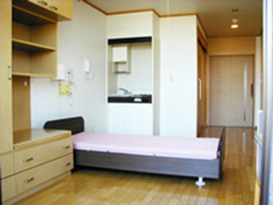 ベッドとキッチンがついた小さなワンルームの様子