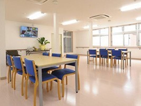 机と椅子が並べられている施設の共有スペースの様子。清潔に整えられた空間