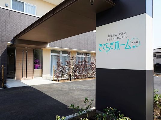 ホーム名が書かれた車寄せは大きく、周辺には木がたくさん植えられている。