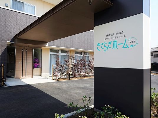 ホーム名が書かれた車寄せは大きく、周辺には木がたくさん植えられている。