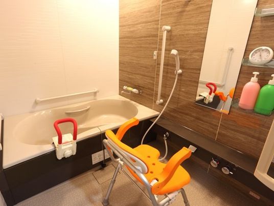 手すりがついている施設内の浴室の様子。シャワーチェアが置いてあるスペースも
