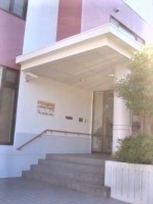 階段には手すりが設置され、玄関周りには木が植えられている。