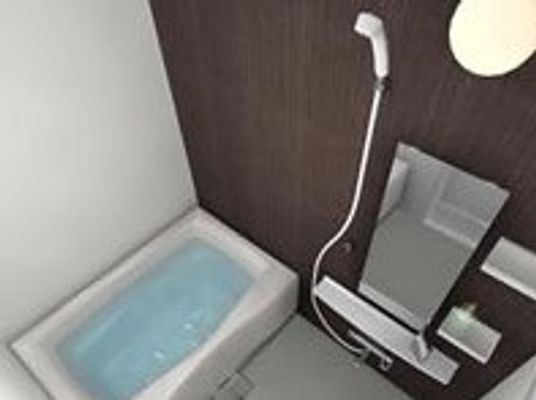 白い浴槽やシャワーが設置されたスタイリッシュな浴室。手すりも設置されている。