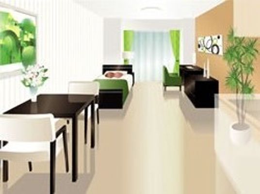 広い居室はダイニングテーブルやベッドを置いてもゆとりがある。観葉植物や絵画が飾られている。