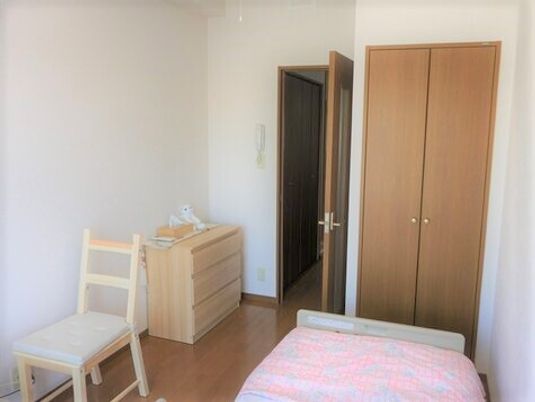タンスやいす、ベッドや収納がある小さなワンルームタイプの部屋