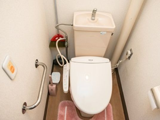 立ち上がり用の手すりがついた施設内のトイレ。高齢者向け設備が整っている様子