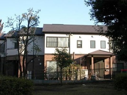 2階建ての建物はツートーンで落ち着いた雰囲気。庭にはたくさんの木も植えられている。