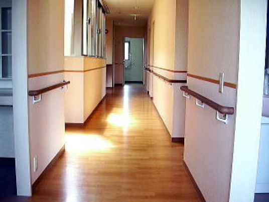 フローリング仕様の床の廊下の様子。壁に満遍なく手すりが取り付けられている