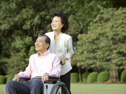 車いすに座る男性と介助する女性