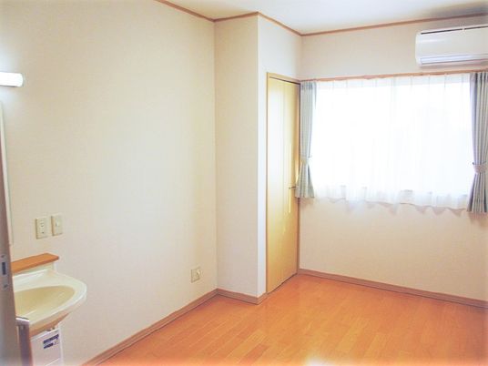 左手前に洗面台がある小さな部屋の様子。奥のほうに窓があり明るい空間