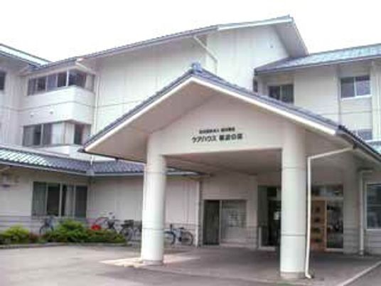 白を基調とした大きな建物は3階建てで、玄関先には屋根が付いた車寄せが設置されている。
