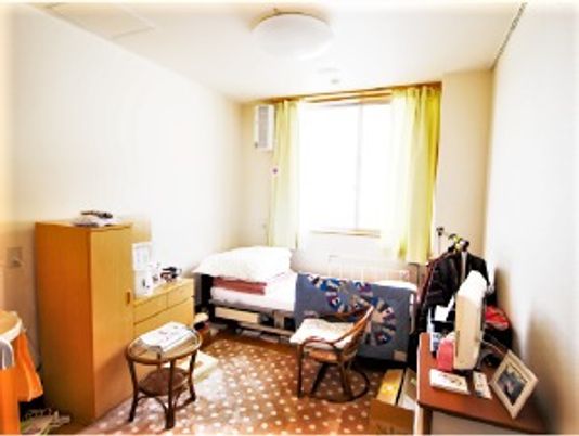 収納やベッド、机などがそろっている施設内の居室の様子。窓があり日差しが差し込んでいる一部屋