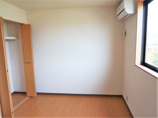 エアコンと収納を写した写真。六畳ぐらいのワンルームの様子