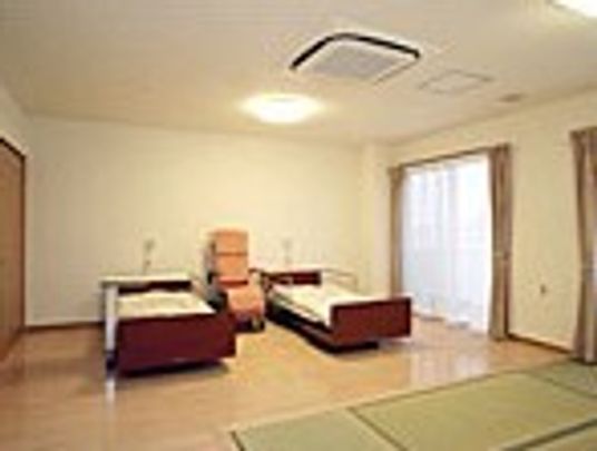 ベッドが二つ並んだ夫婦部屋。フローリングの部屋には畳スペースもある。