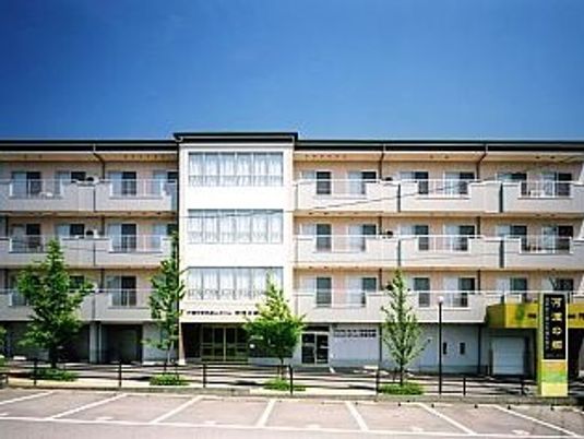 ４階建ての建物は横に長く、広い敷地内には駐車スペースや緑が植えられたスペースもある。