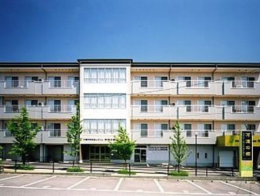 ４階建ての建物は横に長く、広い敷地内には駐車スペースや緑が植えられたスペースもある。