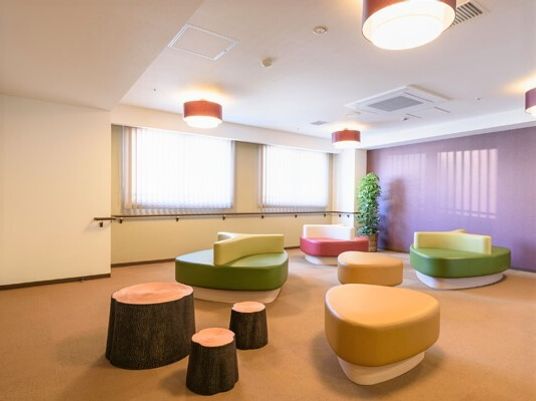 切り株のような形をしたソファ類が置かれている施設内の談話コーナー
