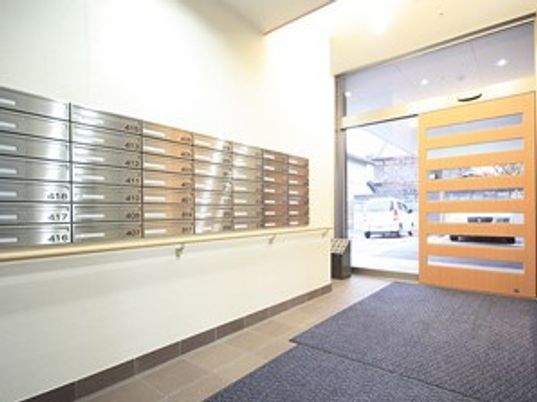 個々の郵便受けがある玄関には段差がなく、それぞれの郵便受けが置かれている。