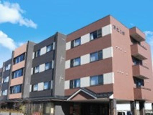 4階建ての建物はブラウン系でまとめられ、屋外に避難階段が設置されている。