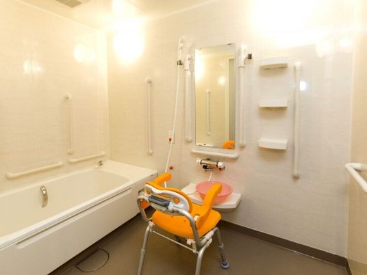 シャワーチェアや手すりがある介護仕様の浴室の様子。施設内に設置された浴室